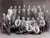 Skolfoto av pojkklass med magister Hellerstedt sittande till vänster.