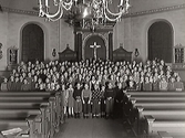 Barnkörerna i Varbergs kyrka framträder. Ett stor barnaskara är samlad framma i koret.