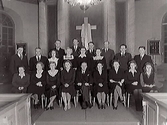 Lindberg-Torpa kyrkokör samlad i kyrkans kor. Ledare August Löfman sitter i mitten.