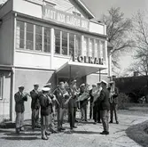 Musikkåren framför Folkets hus entré den första maj. Parollen löd 