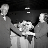 Karl Englund, Valbyrån vid Borgholms stadshus överräcker en bukett blommor till en kvinna.