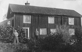 Paret Jonsson framför hus i Vivalla by, ca 1911