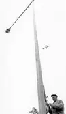 Linjemontör monterar i belysningsmast, 1950-tal