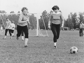 Kvinnliga fotbollsspelare jagar bollen, 1970-talet