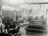 Fabriksinteriör med valsmaskiner som har remdrift. Meddela oss gärna om du har information om motivet!