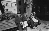Tidningsläsning i parken vid vårdhemmet, 1930-tal