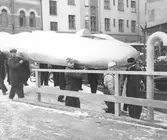 John Cobbs tävlingsbil bärs till Görtz Fordutställning, 1955