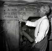 Hemmansägare Ernst Nillson visar inskrift som upplyser om när kvarnen flyttades till platsen.