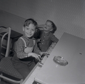 Bild tagen i samband med att flyktingar ifrån Ungern kom 1956.  Två barn som leker och målar.