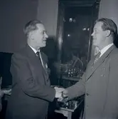 Skytteföreningens årsmöte. Namn som medföljde bild: Ingmar Ekholm. Två män i kostym som skakar hand.