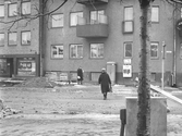 Kvinna på väg över gatan, 1960-tal