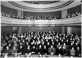 Varbergs teaters salong med publik, taget från scenen. I nederkanten syns några ansikten på musikerna i orkesterdiket.