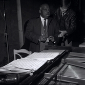 Count Basie och en person vid ett piano, verkar som att CB signerar en sedel.