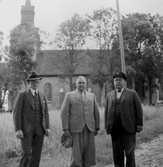 Tre män framför Askersunds landsförsamlings kyrka, 1936-08-14