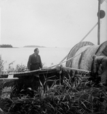 Man vid kabelrulle vid nedläggning av kabel till Vinön, 1952-08-11