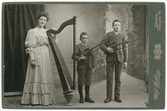 Kabinettsfotografi - en kvinna med harpa och två pojkar med fiol, Uppsala 1906