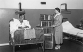 Manlig patient väljer bok på Regionsjukhuset, 1935