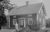 Kvinna framför hus, 1920-tal