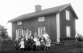 Familj med många barn framför hus, 1920-tal