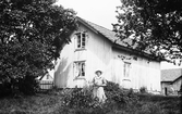 Kvinna framför hus, 1920-tal