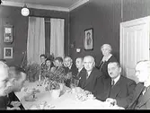 Sockenmöte. Getteröns inkorporering med Varberg firas nyårsafton 1941 i Varbergs församlingshus. Från vänster: cykelarbetaren Erik Weddig, Getterön med fru, cykelarbetare Erland Bengtsson, Getterön, hemmansägaren Hugo Arvidsson, Getterön, dr Erik Uddenberg, Varberg, överläkare Gustav Fransson, Varberg, rådman Gustav Berndtsson, Varberg samt rektor O. Edlund. Stående: fröken Hilda Svensson, Varberg. Fotograferat i Församlingshemmet kv Kyrkoherden 3, Varberg.