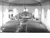 Interiörbild av Valinge kyrka, sett från läktaren mot koret. Bakom altarväggen inryms sakristian. Altarring, altare, predikstol, dopfunt, bänkar.