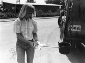 Eva mäter temperatur på asfalt med sticka, 1987