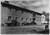 Lastbil och bilar parkerade utanför Viby Folkbibliotek i Vretstorp, 1950-tal