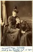 Porträtt av systrarna Annie Adelsköld (g. Wallenberg) och Alma (Maja) Adelsköld. Bilden är tagen av pappa Claes Adelsköld och döttrarna sitter på loggian i hemmet på Villagatan 2, Stockholm.