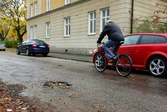 Cyklist passerar potthål i gatan vid Venavägen 21, 2010-10-26