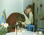 Gäst skriver i besöksboken, 1986 mars