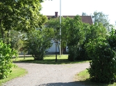 Bondsätters gård bakom träd och buskar, 2006-08-17