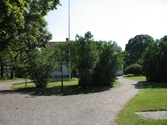 Rundel med träd och buskar framför Bondsätters gård, 2006-08-17