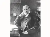 Porträtt av biskop Edvard Rodhe, sittande vid sitt skrivbord. Han var biskop i Göteborgs stift 1888-1929.