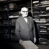 Grosshandlare Karl Danielsson bakom disken expedierar sina kunder tillsammans med Torsten Lundin dagen innan nyårsafton. Danielsson fyllde åttio år vid fototillfället.