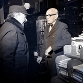 Grosshandlare Karl Danielsson bakom disken expedierar sina kunder tillsammans med Torsten Lundin dagen innan nyårsafton. Danielsson fyllde åttio år vid fototillfället.
