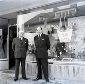 Grosshandlare Karl Danielsson tillsammans med Torsten Lundin utanför butiken dagen innan nyårsafton. Danielsson fyllde åttio år vid fototillfället.