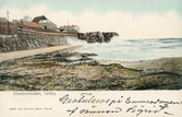 Kolorerat brevkort med vy mot fästningen från Barnens badstrand. Bilden är från cirka 1900.