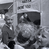Barn, en apa och en man vid entrén till Algutsrums marknad.