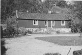 Flygelbyggnad till Stora Klev, Släp. Byggnaden står på hög stenfot nedanför ett berg. I förgrunden gårdsrundeln.