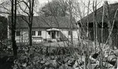 Bostadshus med farstukvist och till höger en ekonomibyggnad, Vallda kyrkby. (Se även bildnr G8441)