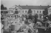 Marknad år 1948 med bland annat laggkärl, spån- och flätkorgar på Kungsbacka torg. I bakgrunden ses byggnaden i kv Tullen 8, kallad Gamla Gästis eller Medinska fastigheten, som var en av de första byggnaderna som uppfördes efter den stora branden i Kungsbacka 1846. Då var den ett av få tvåvåningshus i staden. Vid tiden för bilden låg Göteborgs Bank och en Möbleringsbolaget i huset. I den högra gavelprydda delen av huset låg under många decennier Kristianssons Kafé, som dels hade en enklare öl- och smörgåslokal, dels en mer ombonad konditorilokal.
Den 16 september 2006 ödelades det anrika huset i en ny brand.