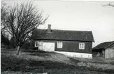 Mindre gård med vitfärgad stenfot öster om Billdal.