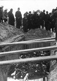 15 personer begravs vid kyrkogården i Ockelbo, som offer för Spanska sjukan. Sörjande framför graven.