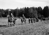 Uppträdande - två män till häst samt män med spjut i procession, Uppsala 1935