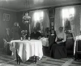 Tre kvinnor, en man och en liten flicka samlade i finrummet i 