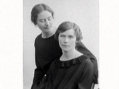 Två unga kvinnor i mörka klänningar, där den ena tittar in i kameran medan den andra riktar blicken mot henne. Fröken Bergendahl beställde bilden och är troligen en av kvinnorna.