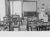 Interiör av Konditori Mignon med cafébord och kassadisken till höger.