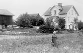 Äldre dam framför Svenssons gård i Bettorp i Hovsta, 1930-tal