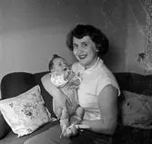 Kvinna med barn sittandes i soffa.
Familjen Hjalmar Frisk.